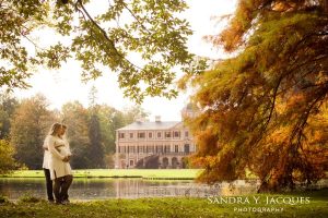 In einem Park mit Schloss steht ein Paar mit schwangerer Frau©sandra-jacques